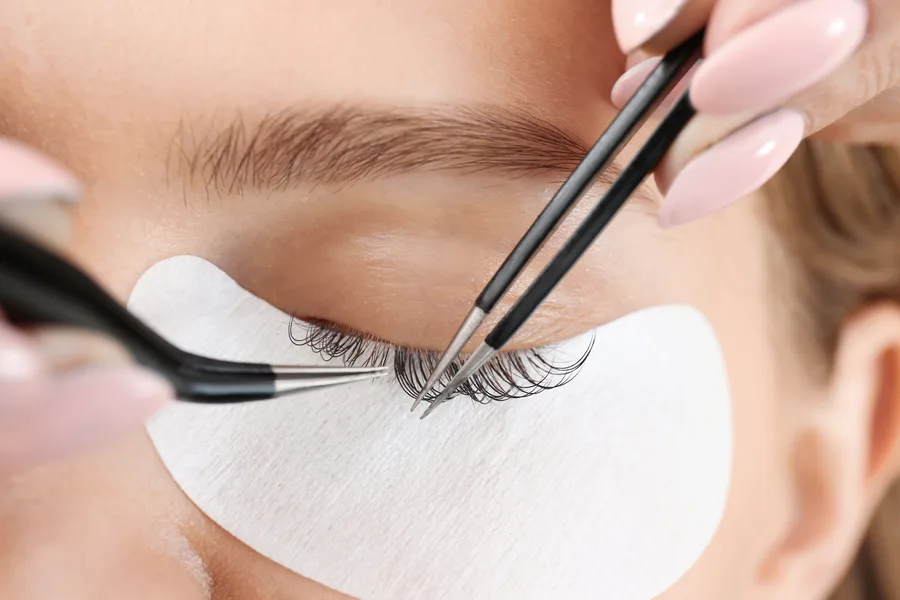 Lash technician applying eyelash extensions before a wedding